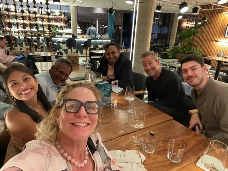 Doceree team celebrates together, smiling and posing for a selfie at a networking dinner after the "Future of Pharmaceutical Marketing in the Era of Data & AI" event.